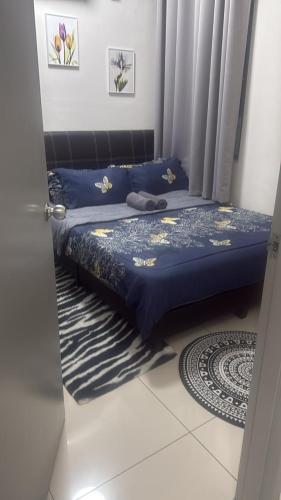 a bedroom with a bed with blue sheets and curtains at Meeymohd Homestay in Ipoh
