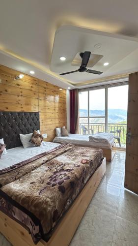 a large bedroom with two beds and a ceiling fan at Hotel Classic Crown - #Scenic mountain view #open terrace #guest preferred #best selling hotel in Mussoorie in Mussoorie