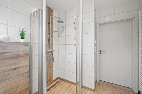 a shower with a glass door in a bathroom at Am-Nordmeerstrand in Norddeich