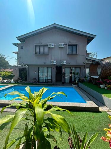 a house with a swimming pool in front of it at TC Maya Abaya Hotel in Kuantan
