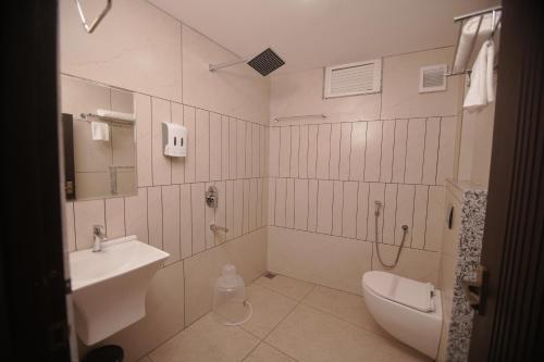 a bathroom with a toilet and a sink at Empire Suites in Erāttupetta