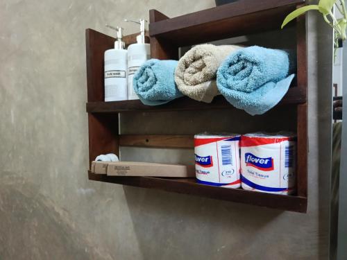 a wooden shelf with towels and toiletries on it at Wilpattu Wild Villa in Pahala Maragahawewa
