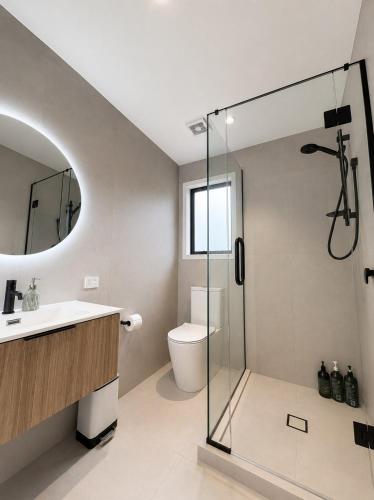 a bathroom with a shower and a toilet and a sink at The palms farmhouse in Puketona