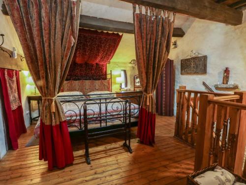 a bedroom with a bed with red curtains at Moldy Warp Barn in Keighley