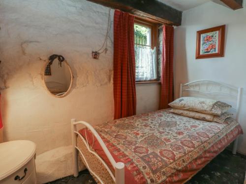 a bedroom with a bed and a mirror and a window at Moldy Warp Barn in Keighley