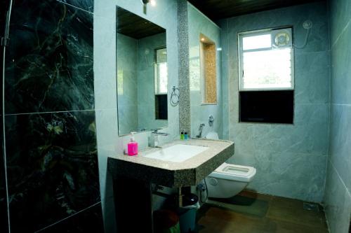 a bathroom with a sink and a toilet and a mirror at Hotel green hills in Waki