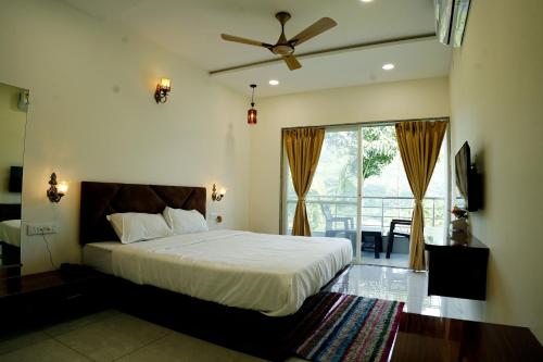 a bedroom with a bed with a ceiling fan at Hotel green hills in Waki