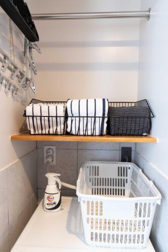 a laundry room with a white basket on a shelf at ウミチカ in Minamiboso