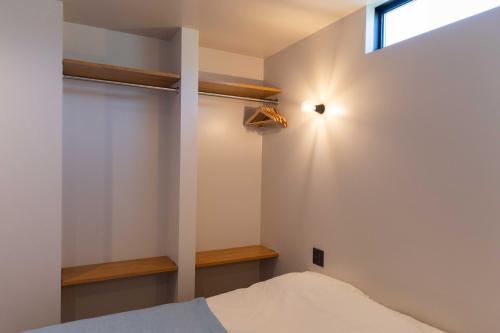 a bedroom with a bed and a window at ウミチカ in Minamiboso