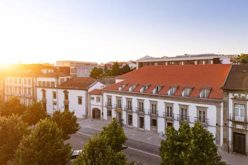 an old building with a red roof in a city at INNSiDE by Meliá Braga Centro in Braga