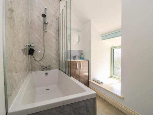 a white bath tub in a bathroom with a window at Dale Barton in Wells