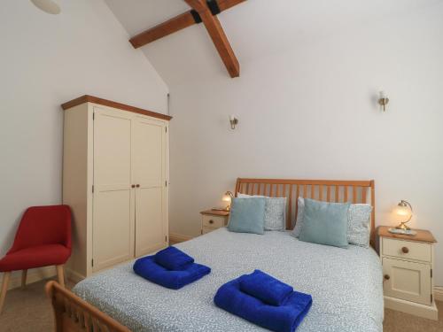 a bedroom with a bed with blue pillows on it at Dale Barton in Wells