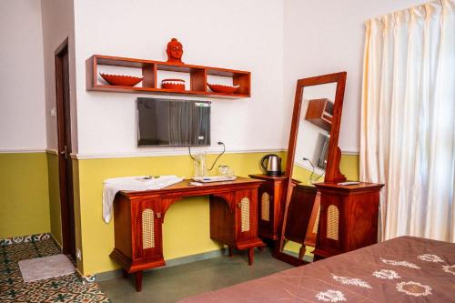 a bedroom with a dressing table and a mirror at Illam By Santhi in Varkala