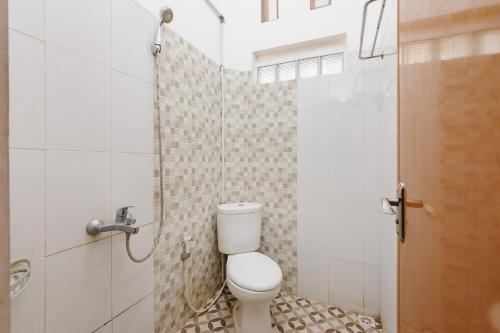 a bathroom with a toilet and a shower at RedDoorz @ Jalan Danau Limboto in Malang