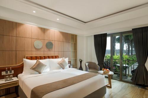 a hotel room with a bed and a balcony at Enrise By Sayaji Somnath in Somnath