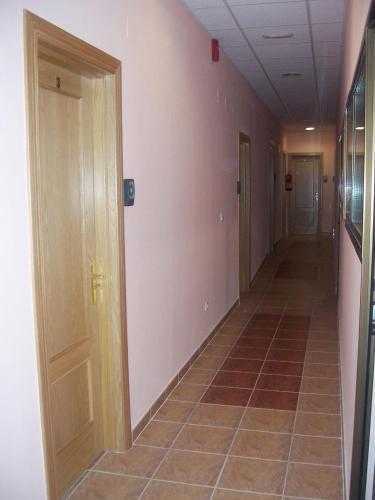 an empty hallway with doors and a tile floor at Hostal San Marcos II in Guadalajara