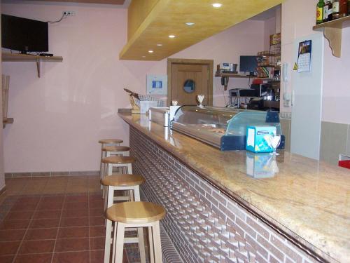 a bar in a restaurant with stools at Hostal San Marcos II in Guadalajara