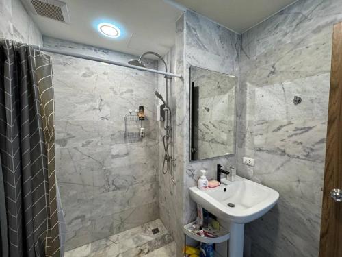 a bathroom with a sink and a shower at Cozy apartment with a sea view in Ban Bo Sai Klang
