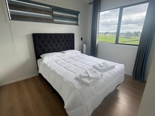 a bedroom with a large bed with a large window at 2 Bedroom Granny Flat in Runciman