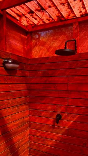 a bathroom with a wooden wall with a light on it at Terracotta River Hideaway in Maun
