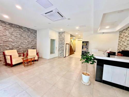 a large living room with a brick wall at Pertama Lodge in Tawau