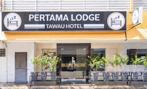 a building with a sign for a tarani hotel at Pertama Lodge in Tawau