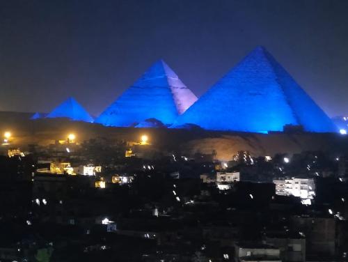 a view of the pyramids of giza at night at malak pyrameds rofe top in Cairo
