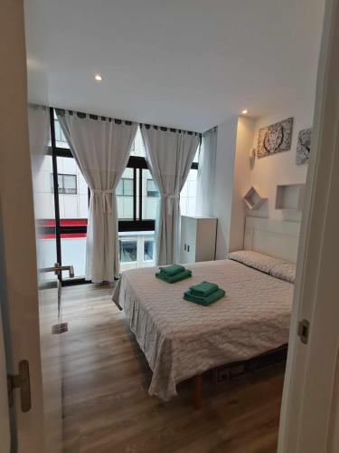 a bedroom with a bed and a large window at Apartamento Carreira Sada in Sada