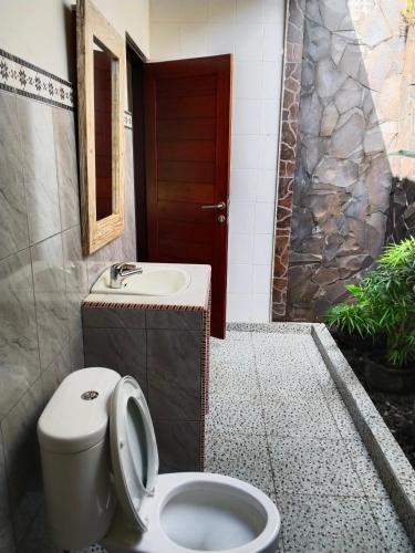 a bathroom with a toilet and a sink at Pondok Alam Bukit in Tirtagangga