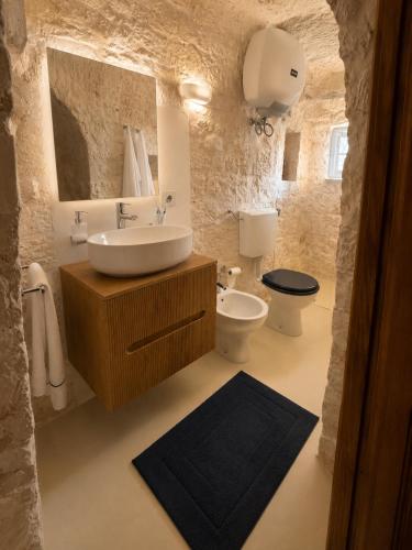 a bathroom with a sink and a toilet at I Trulli di Federico in Selva di Fasano