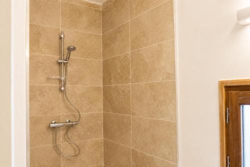 a shower with a shower head in a bathroom at Le Mas de la Vivande in Marsanne