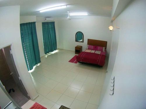 a bedroom with a red bed and green curtains at MARMA Homestay Melaka in Ayer Keroh