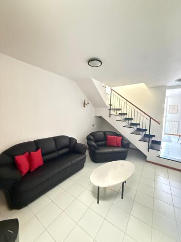 a living room with a black couch and a table at Happy Haven al mare in Riviera in Chiavari