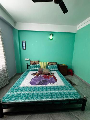 a bedroom with a bed with a blue wall at Subba Stays in Siliguri