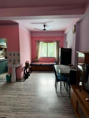 a room with a bed and a table and a window at Subba Stays in Siliguri