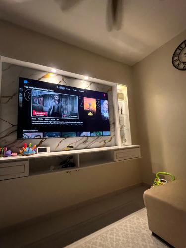 a living room with a flat screen tv on a wall at Villa Hayfa in Kuala Kerai