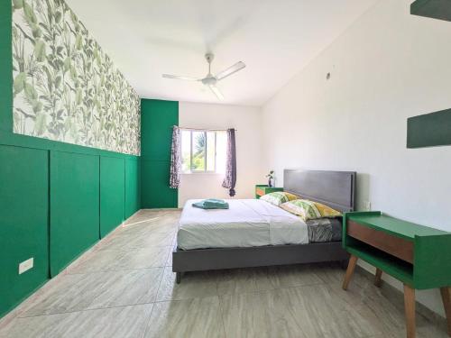 ein Schlafzimmer mit grünen Wänden und einem Bett und einem Schreibtisch in der Unterkunft Hostel Humanity - Puerto Morelos in Puerto Morelos