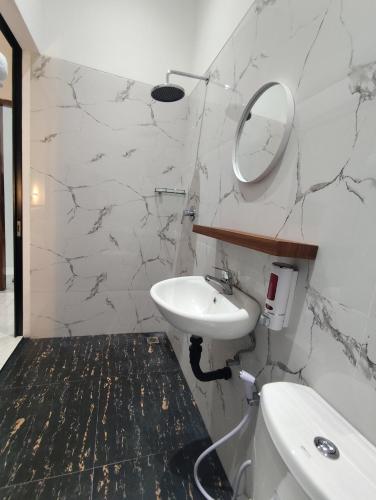 a bathroom with a sink and a mirror at Moonrise Rooms in Uluwatu
