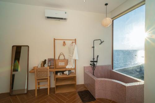 a bathroom with a large window with a view of the ocean at Hani Boutique Hotel Phú Quý in Cù Lao Thu