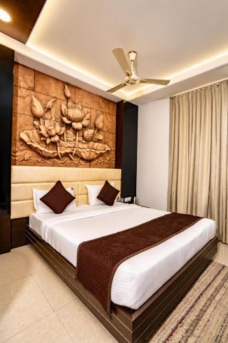 a bedroom with a large bed with a wooden headboard at Hotel Sawamani - 100 Meters from Khatushyam ji in Khātu