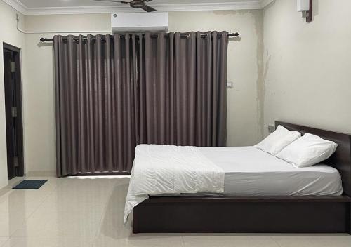 a bedroom with a bed and a large window at Palm Breeze Villa in Mannar