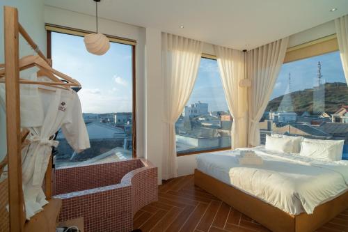 a bedroom with a bed and a large window at Hani Boutique Hotel Phú Quý in Cù Lao Thu