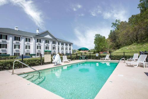 a woman walking by a swimming pool in front of a building at Quality Inn Greeneville - Tusculum in Greeneville