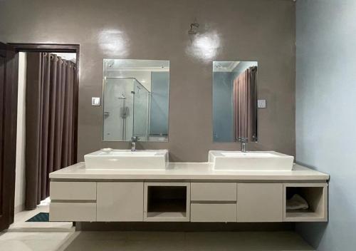 a bathroom with two sinks and a large mirror at Palm Breeze Villa in Mannar