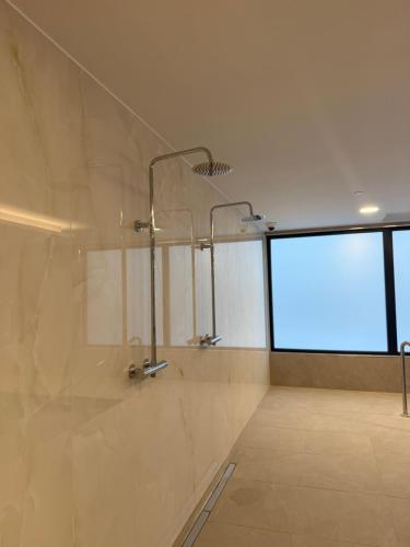 a bathroom with two shower heads and a large window at New CP Victory suites studio sleeps 4 with pool and gym in Gibraltar