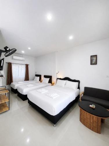 a bedroom with two beds and a couch in it at Yada House Cozy Place in Nai Yang Beach