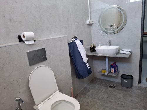 a bathroom with a white toilet and a sink at Journeyman Ocean Deck in Marakkānam