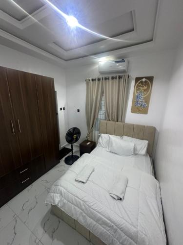 a bedroom with a large white bed and a cabinet at April shortlet apartments in Lagos