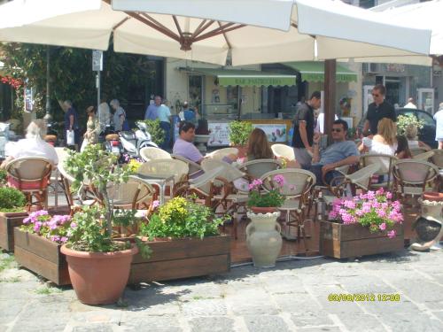a group of people sitting at an outdoor cafe with potted plants at B&B Celestina Ischia in Ischia