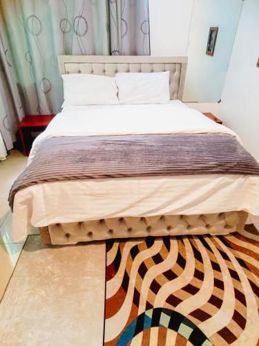 a bedroom with a bed with a wooden frame and a rug at AWESOME HOME's in Arusha